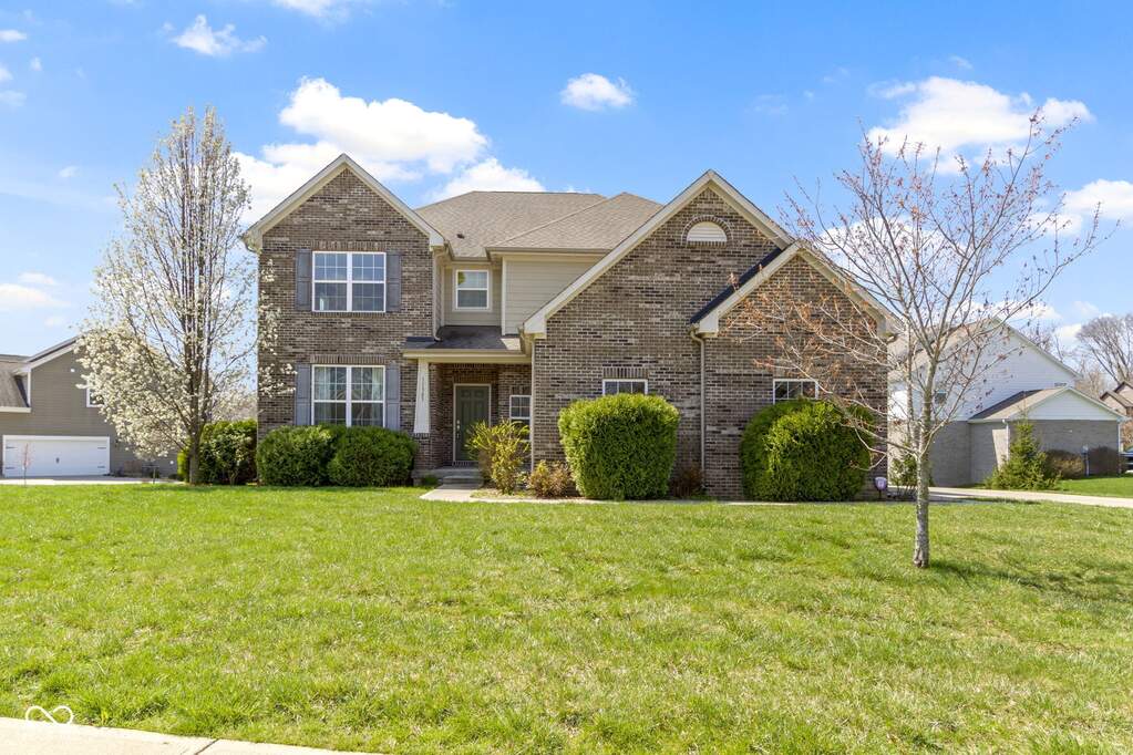 view of front of property featuring brick siding, a front yard, and roof with shingles at 11383 Sea Side Court, Fishers, IN 46040