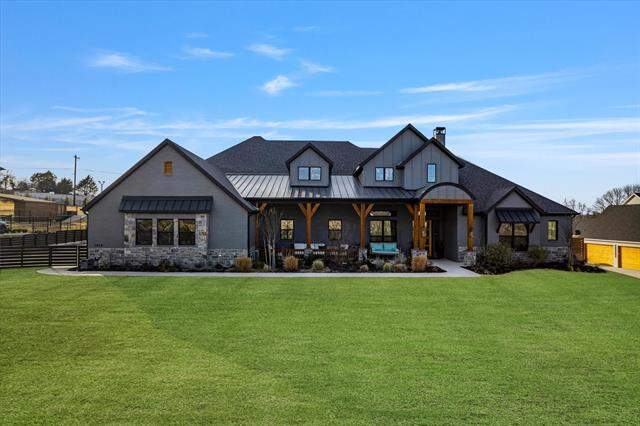 Modern farmhouse style home featuring a standing seam roof, a metal roof, stone siding, a porch, and a chimney at 1414 Tucker Place, Celina, TX 75009