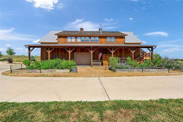 View of front of home featuring a porch, driveway, a chimney, and board and batten siding at 5555 County Road 179, Celina, TX 75009